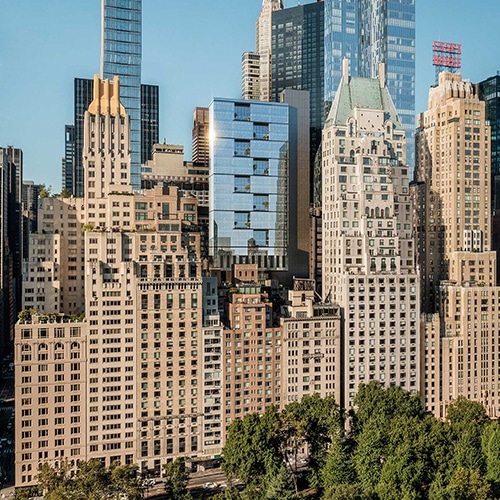 A new glass building surrounded by old stone buildings